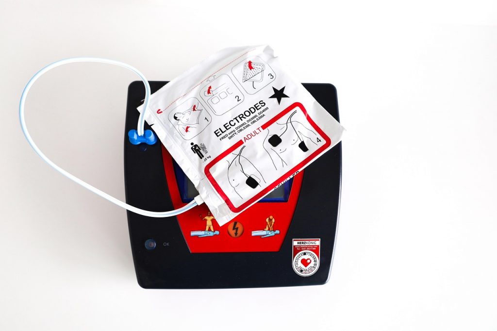 Een AED-apparaat gemonteerd op een muur in een openbare ruimte, klaar voor gebruik bij een noodsituatie