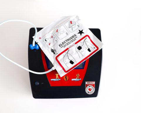 Een AED-apparaat gemonteerd op een muur in een openbare ruimte, klaar voor gebruik bij een noodsituatie