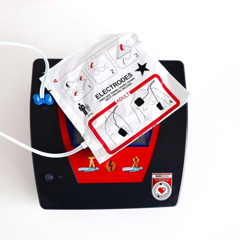 Een AED-apparaat gemonteerd op een muur in een openbare ruimte, klaar voor gebruik bij een noodsituatie