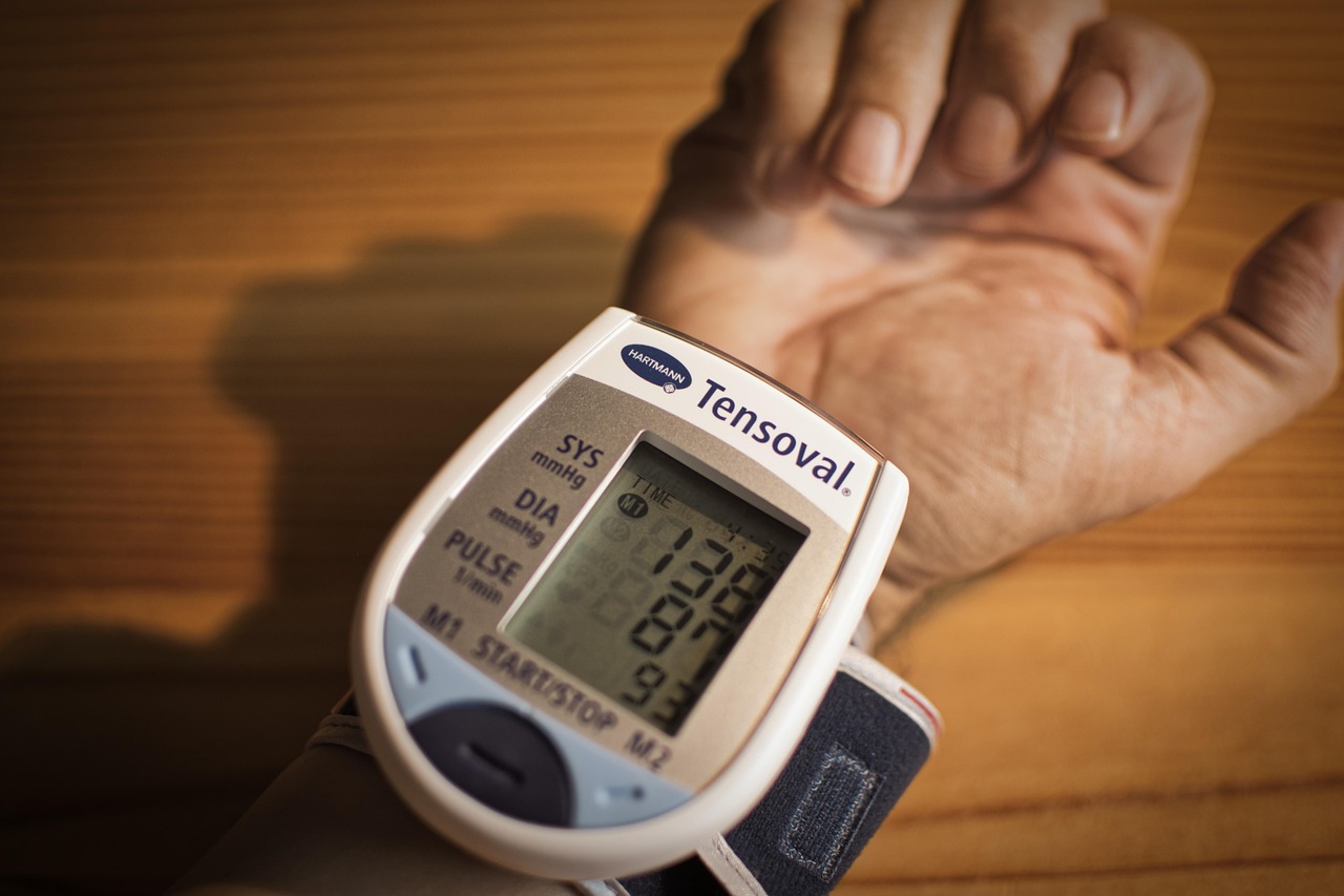 Persoon die thuis bloeddruk meet met een bovenaarmsmeter