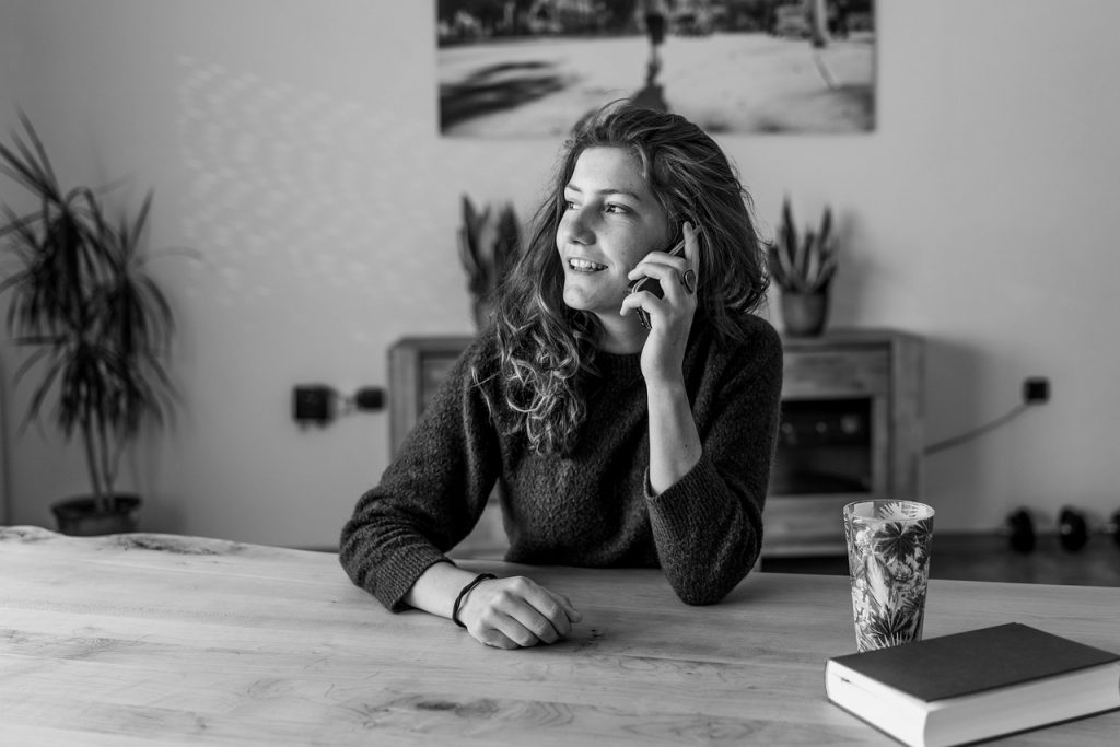 Een oudere man en vrouw in gesprek met een verpleegkundige aan de keukentafel thuis