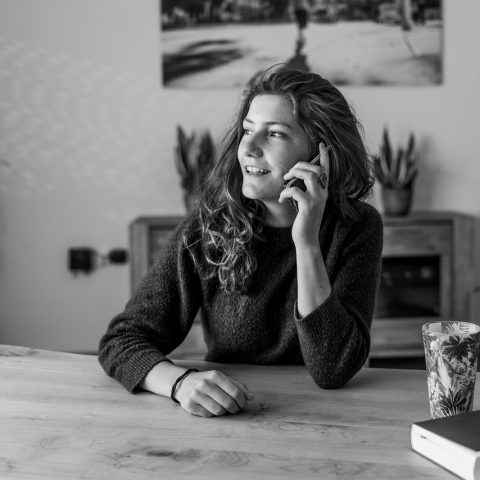 Een oudere man en vrouw in gesprek met een verpleegkundige aan de keukentafel thuis