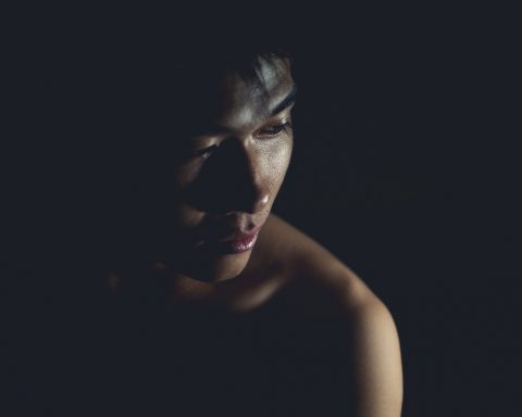 Vrouw die een rode plek op haar onderarm bekijkt bij goed licht