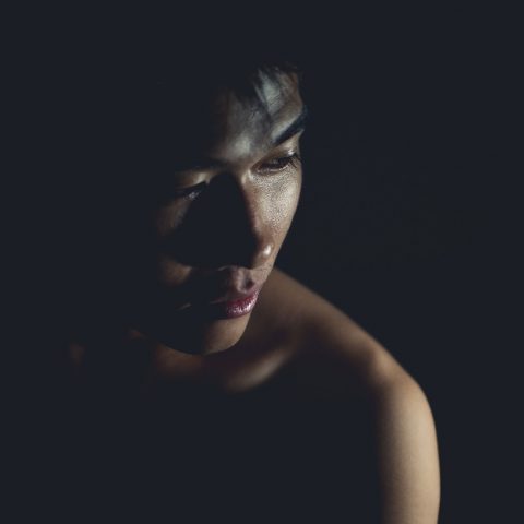 Vrouw die een rode plek op haar onderarm bekijkt bij goed licht