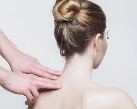 Fysiotherapeut behandelt de schouder van een patiënt in een fysiotherapiepraktijk