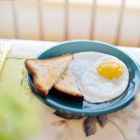 Een gedekte ontbijttafel met yoghurt, fruit, noten en volkorenbrood