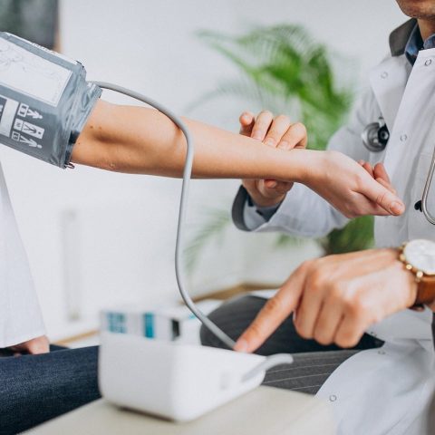Persoon meet bloeddruk thuis met een bovenarm-manchet
