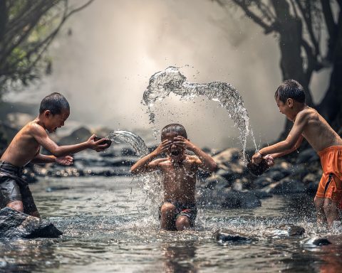 Kinderen van verschillende leeftijden spelen samen buiten in een park