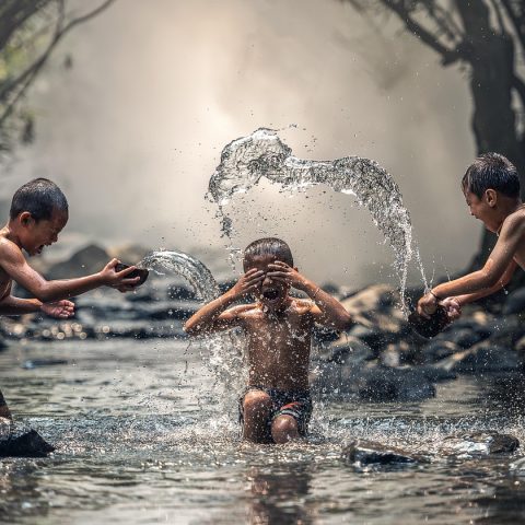Kinderen van verschillende leeftijden spelen samen buiten in een park