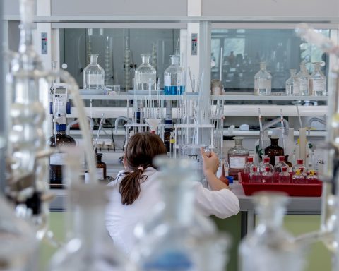 Wetenschapper in laboratorium die grafeenmateriaal onderzoekt onder microscoop