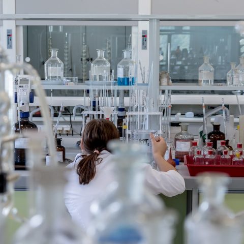 Wetenschapper in laboratorium die grafeenmateriaal onderzoekt onder microscoop