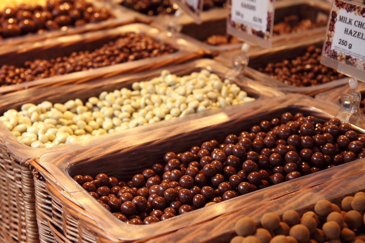 Een houten plank met verschillende noten, zaden en stukjes pure chocolade als koperrijke voedingsmiddelen