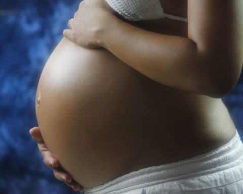 Persoon die hand op maagstreek houdt vanwege buikpijn