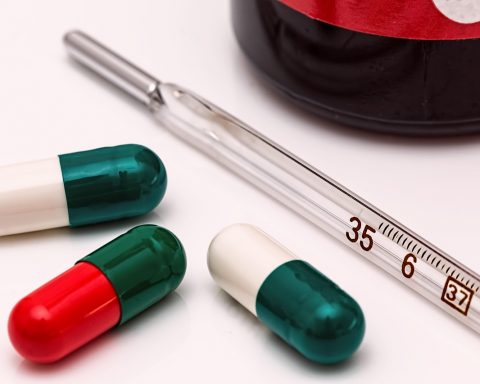 Persoon die medicijnen controleert in een warme zomerse omgeving