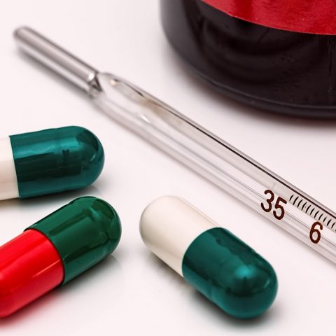 Persoon die medicijnen controleert in een warme zomerse omgeving