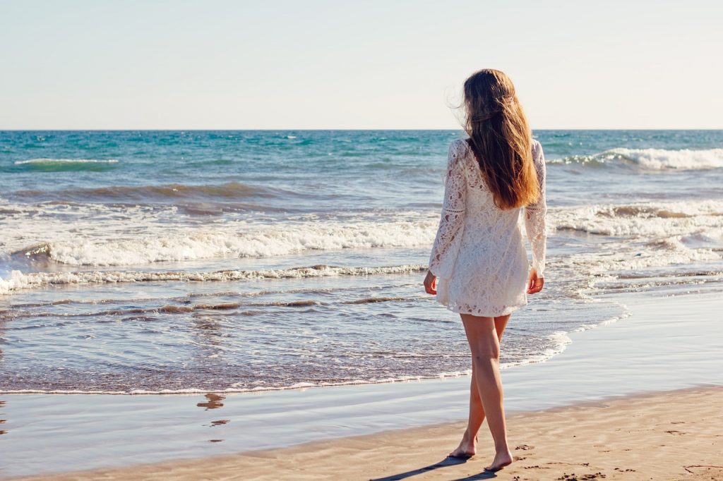 Vrouw wandelt tijdens een zomerse avond in een groene omgeving