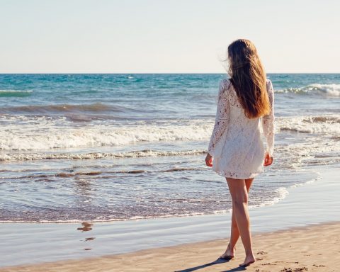 Vrouw wandelt tijdens een zomerse avond in een groene omgeving