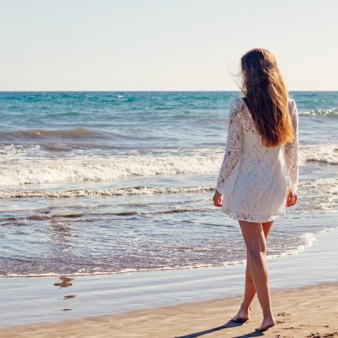 Vrouw wandelt tijdens een zomerse avond in een groene omgeving