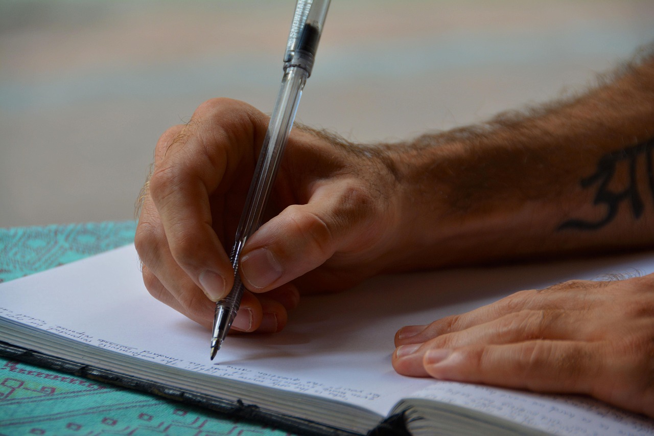 Persoon schrijft in een dagboek aan een bureau om stemming en gedachten bij te houden