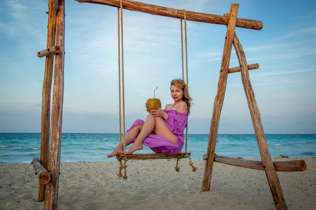 Vrouw drinkt water op het strand op een zonnige vakantiedag