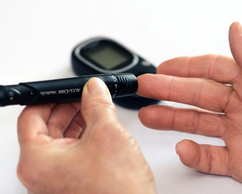 Arts die de bloedsuiker controleert bij een patiënt met diabetes type 2