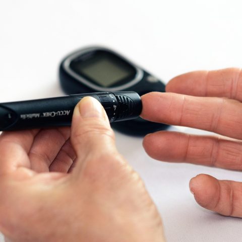 Arts die de bloedsuiker controleert bij een patiënt met diabetes type 2