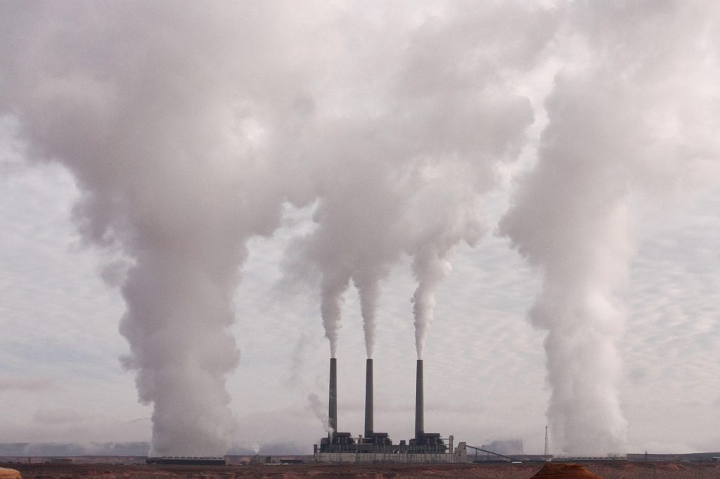 Schoorsteen van een industriegebied met rook tegen een bewolkte lucht