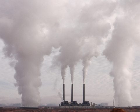 Schoorsteen van een industriegebied met rook tegen een bewolkte lucht