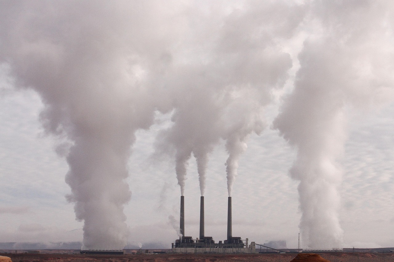 Schoorsteen van een industriegebied met rook tegen een bewolkte lucht