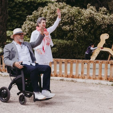 Oudere vrouw loopt met een rollator op een klinkerpad buiten