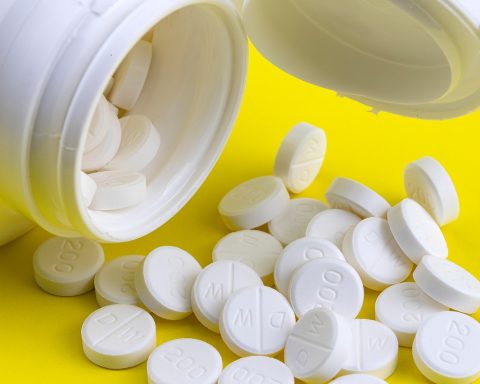 Verschillende supplementenpotjes met vitamine D, zink en probiotica op een plank in een drogisterij