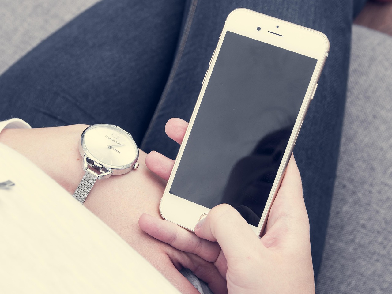 Persoon die een symptoomchecker op de smartphone gebruikt terwijl hij op de bank zit