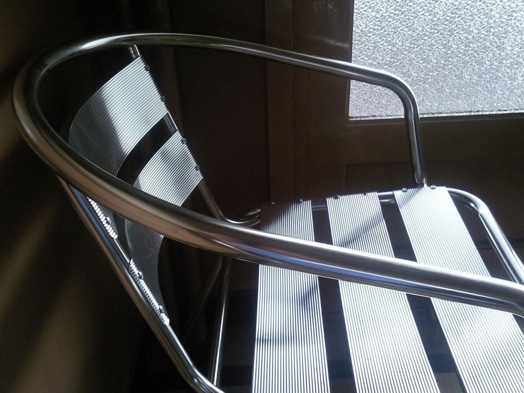 Een moderne, lichte wachtkamer van een tandartspraktijk met stoelen en een balie op de achtergrond