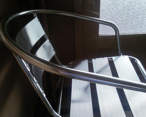 Een moderne, lichte wachtkamer van een tandartspraktijk met stoelen en een balie op de achtergrond