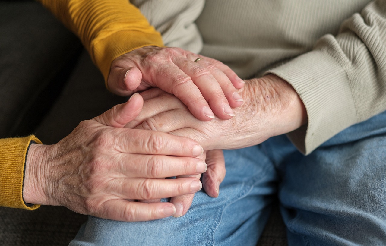 Een verpleegkundige helpt een oudere vrouw thuis met haar verzorging