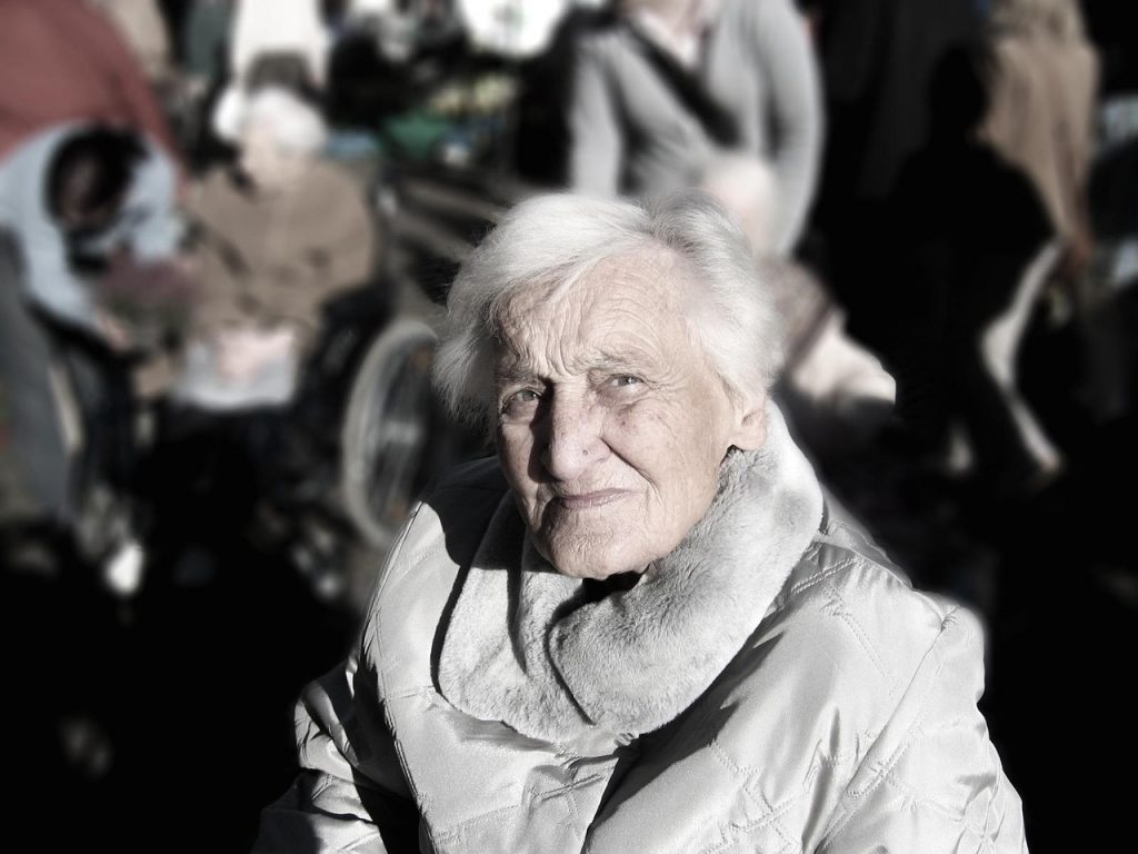 Een oudere vrouw zit samen met een mantelzorger aan tafel en bespreekt zorgopties