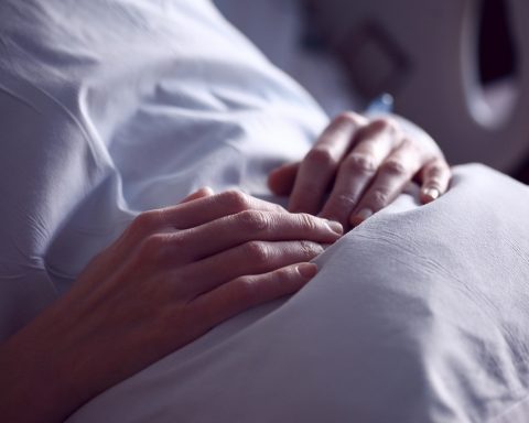 Een vrouw rust op een bank thuis tijdens haar herstel na ziekte