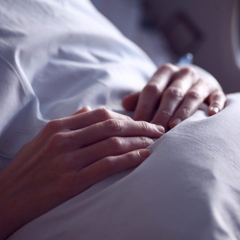 Een vrouw rust op een bank thuis tijdens haar herstel na ziekte