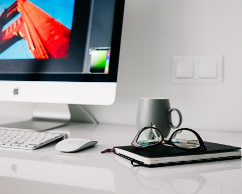 Een ergonomisch ingerichte thuiswerkplek met verstelbare bureaustoel, extern beeldscherm op ooghoogte en een opgeruimd bureau