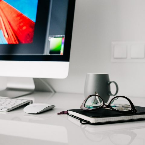Een ergonomisch ingerichte thuiswerkplek met verstelbare bureaustoel, extern beeldscherm op ooghoogte en een opgeruimd bureau