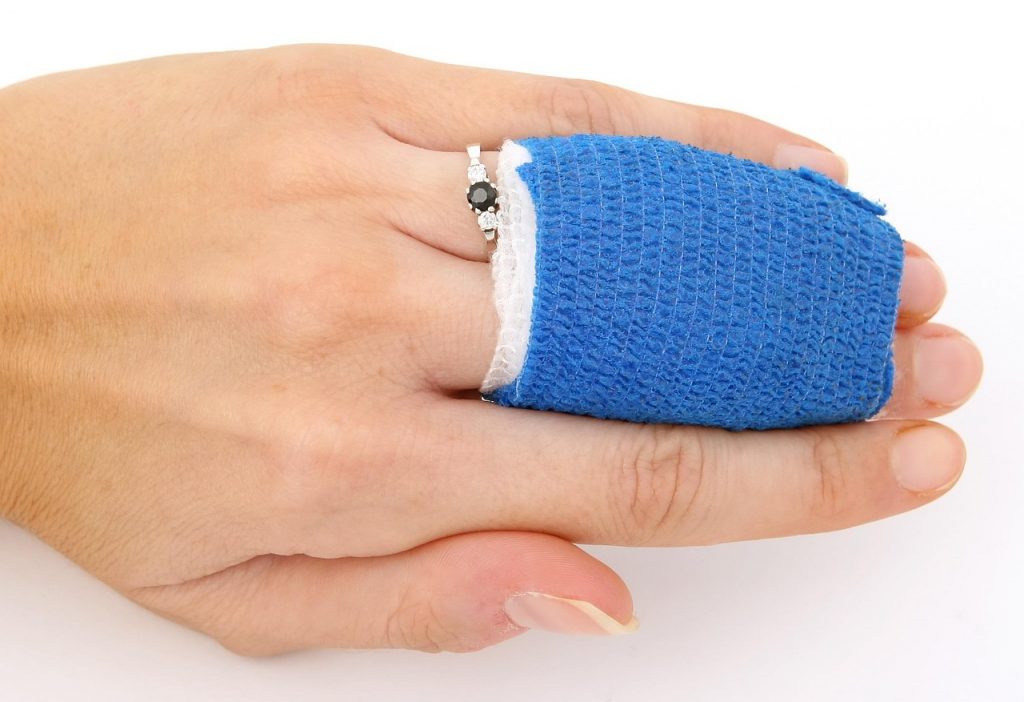 Persoon wisselt thuis een verband op de arm na een kleine operatie