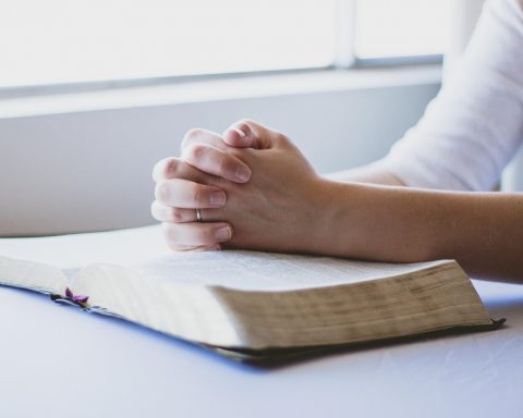 Persoon die zorgverzekeringspolisvoorwaarden doorleest aan een keukentafel
