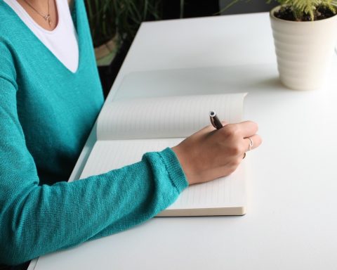 Verpleegkundige die administratie doet aan een bureau, bezig met het berekenen van haar zzp-tarief