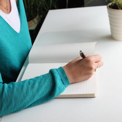 Verpleegkundige die administratie doet aan een bureau, bezig met het berekenen van haar zzp-tarief